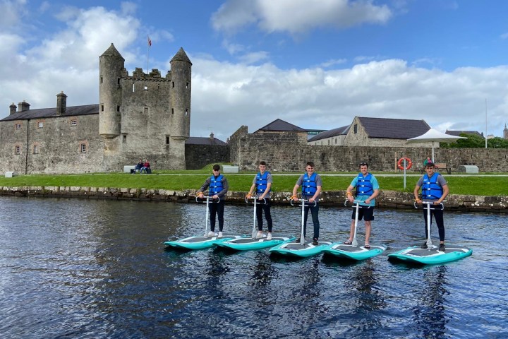 a group of people standing next to a body of water